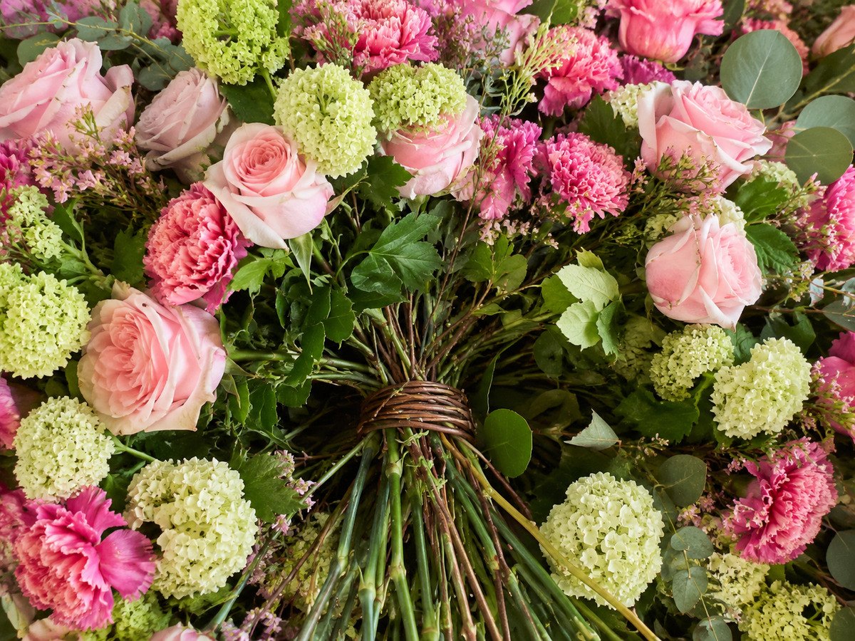 Rosa Rosen, Nelken und hellgrüne Schneeballblüte dicht an dicht